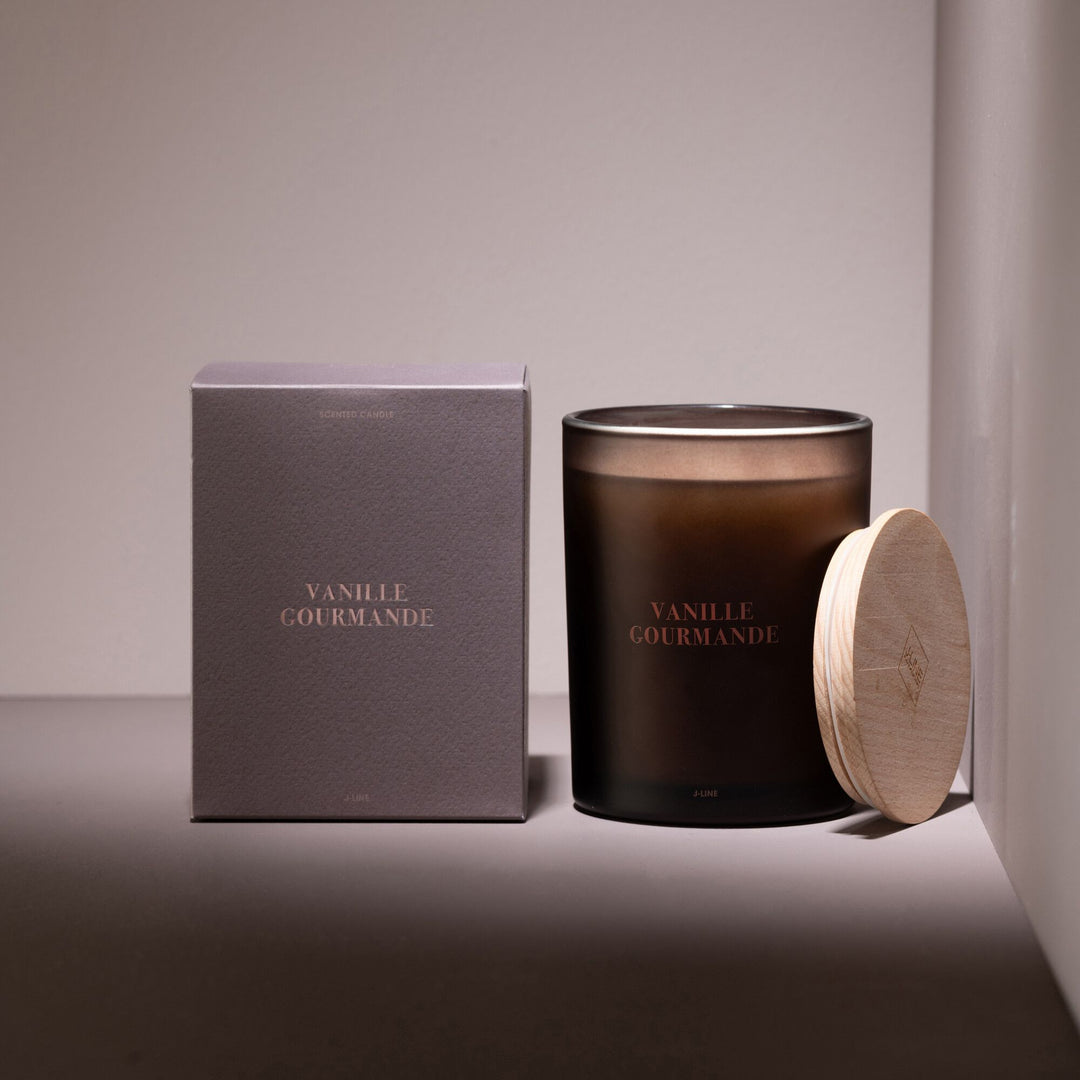 Vanille Gourmande candle styled in a warm setting with packaging and soft lighting.