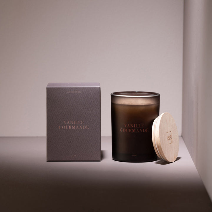 Vanille Gourmande candle styled in a warm setting with packaging and soft lighting.