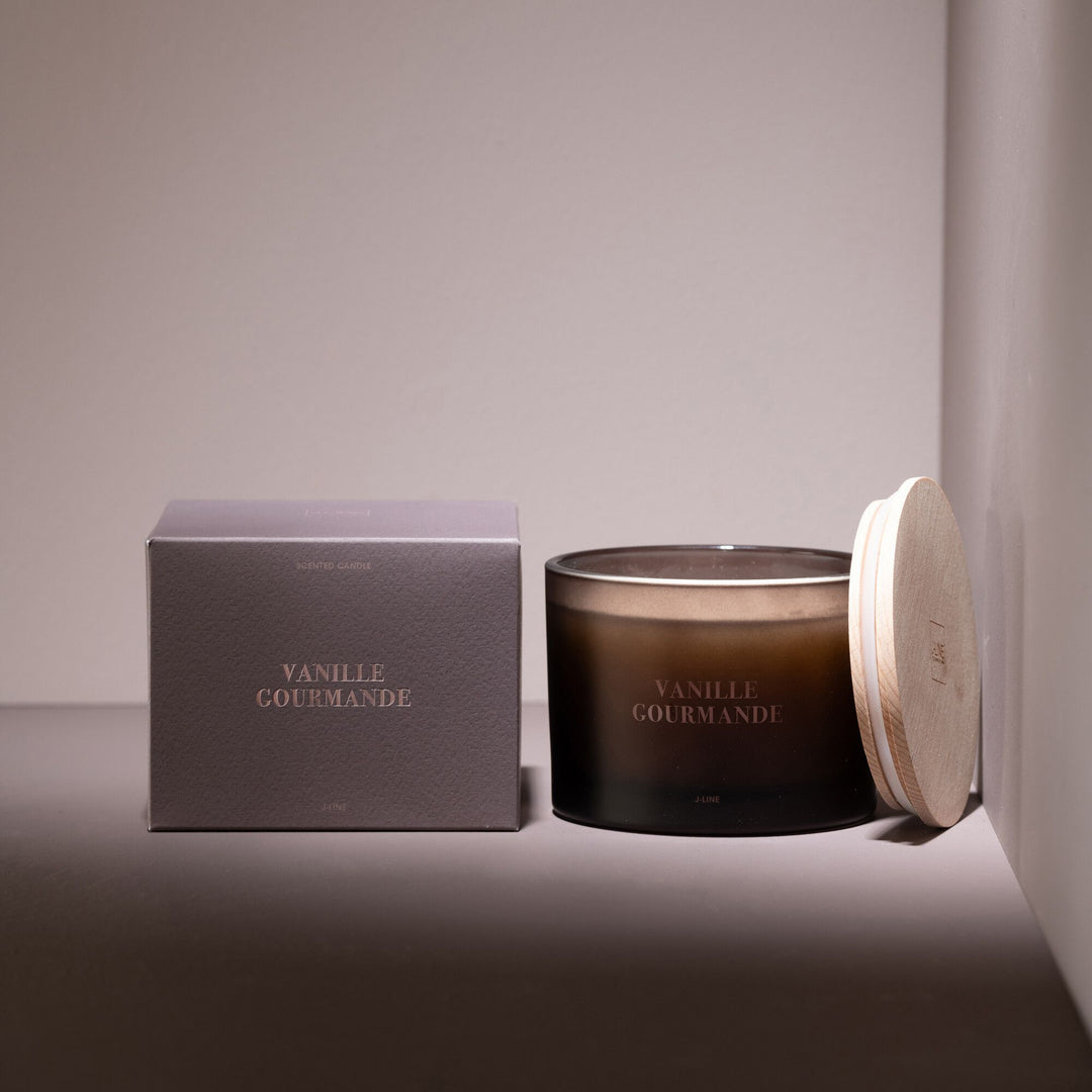 Vanille Gourmande candle styled in a warm setting with packaging and soft lighting.