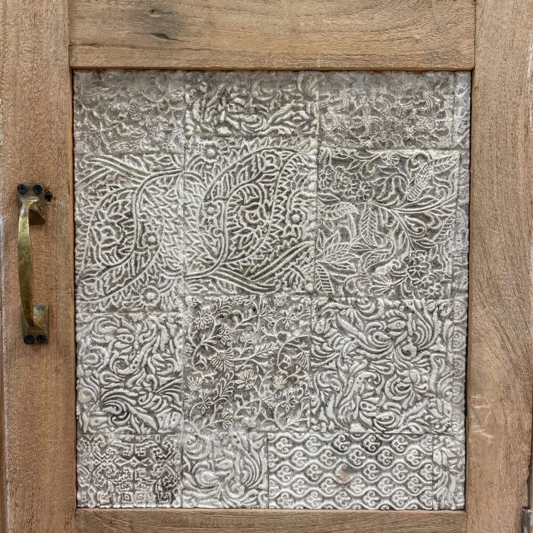 Close-up detail of the decorative carved panel on the wardrobe door.