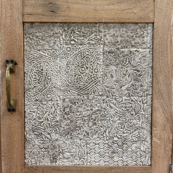 Close-up detail of the decorative carved panel on the wardrobe door.