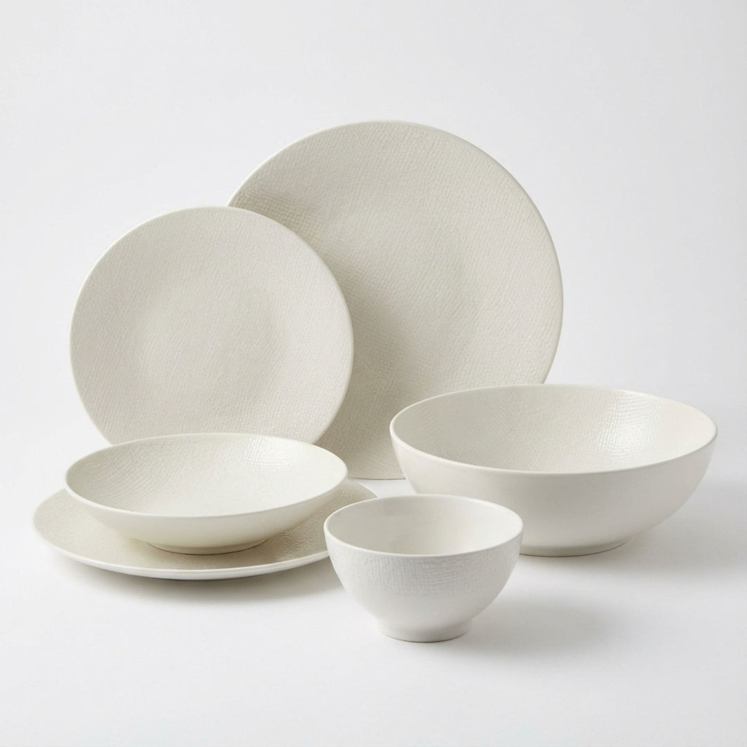 White Vesuvio ceramic tableware set with plates and bowls in a minimalist design.