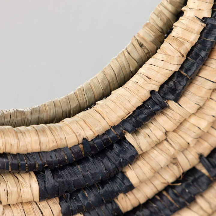 Close-up of the Zuri Mirror II highlighting the layered seagrass weave and circular black detailing