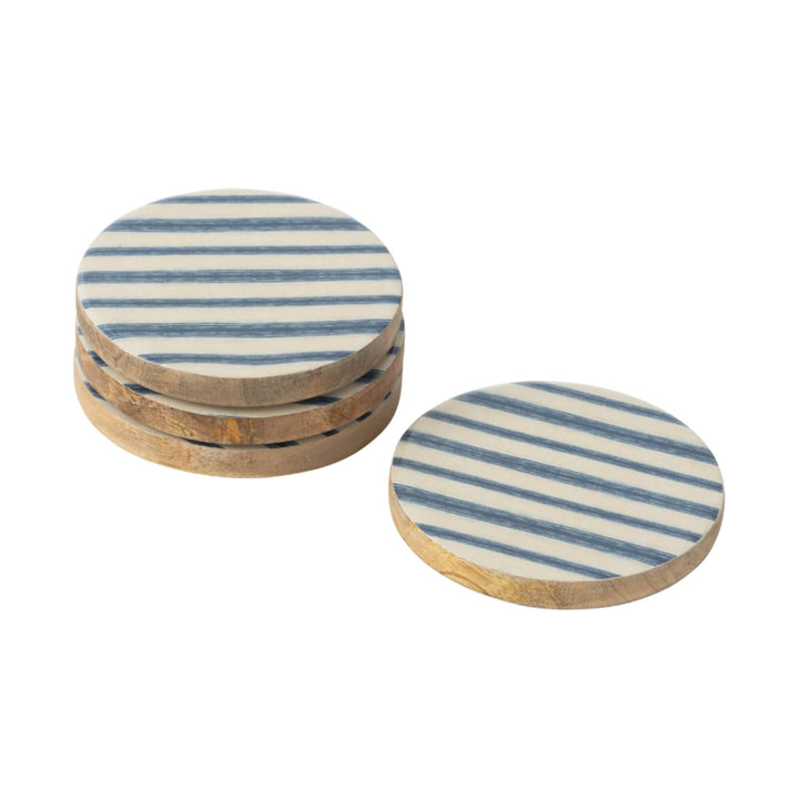 Set of four Anaya Stripes coasters in natural wood with blue diagonal pattern.