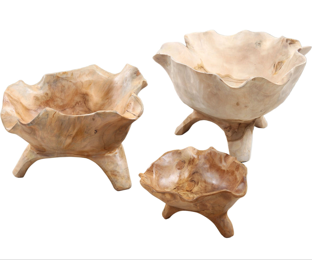 Three handmade teak wood bowls of different sizes with a natural beige color, displayed on a white background. Each bowl has three small legs and a unique organic shape.