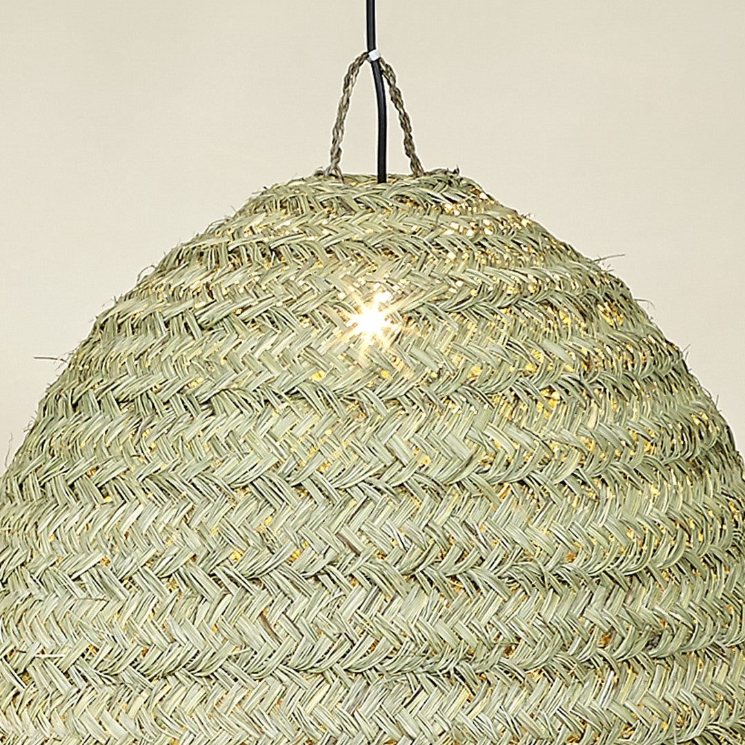 Top view of natural fiber dome lamp glowing softly.