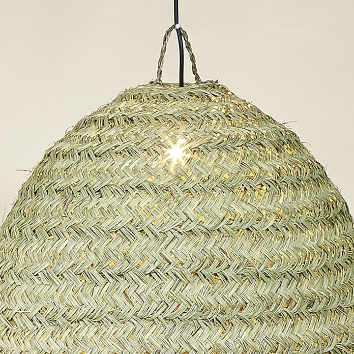 Top view of natural fiber dome lamp glowing softly.