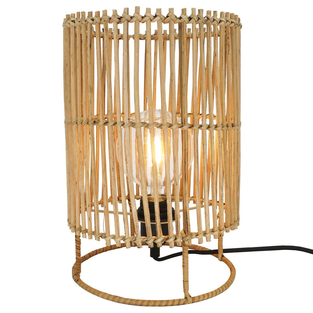 Small Sun Rattan Lamp standing on table with warm glow.