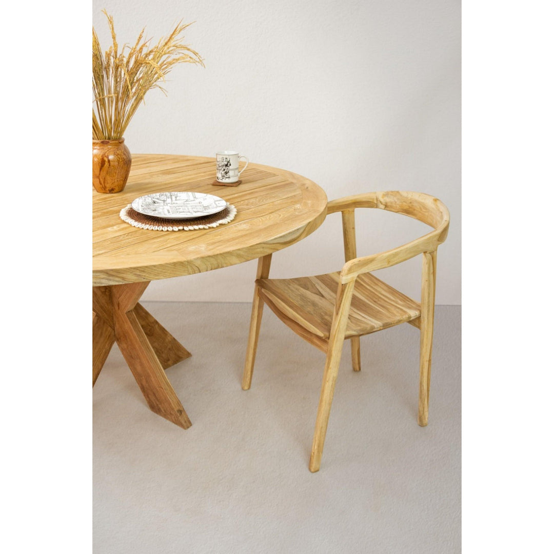 Side angle of the teak Tongariki table styled with dining chairs.